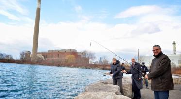 three people casting fishing rods into Lake Ontario