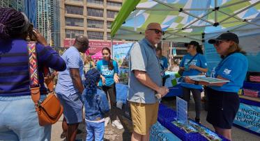 people speaking to staff at a waterfront event