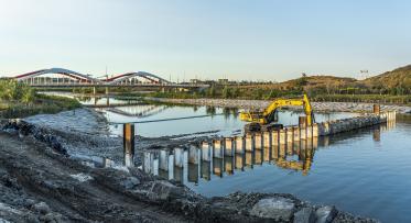 An excavator removing part of the north plug of a river.