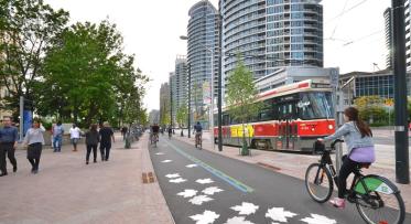 A view of the new extended south side granite promenade, the Martin Goodman Trail and the new streetcar tracks on the revitalized Queens Quay.