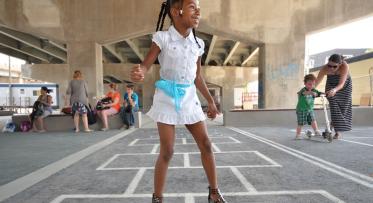 Kids playing at the hopscotch court at Underpass Park. 